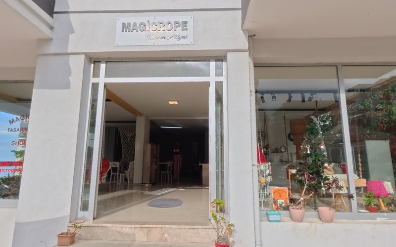MagicRope Tasarım Atölyesi cephesi: kapı üstünde MAGICROPE tabelası, açık cam kapı ve sağda makrome ürünlerle dolu vitrin